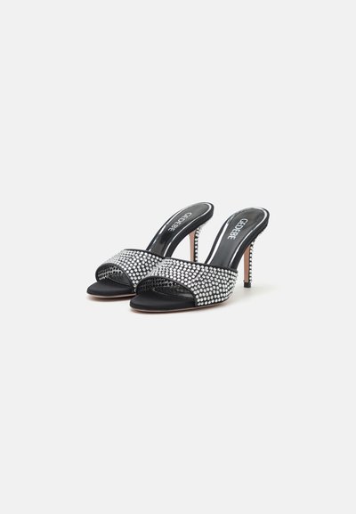 Black satin slingback heels with a jeweled strap. Features an open toe, slender heel, and a smooth texture with shiny accents.