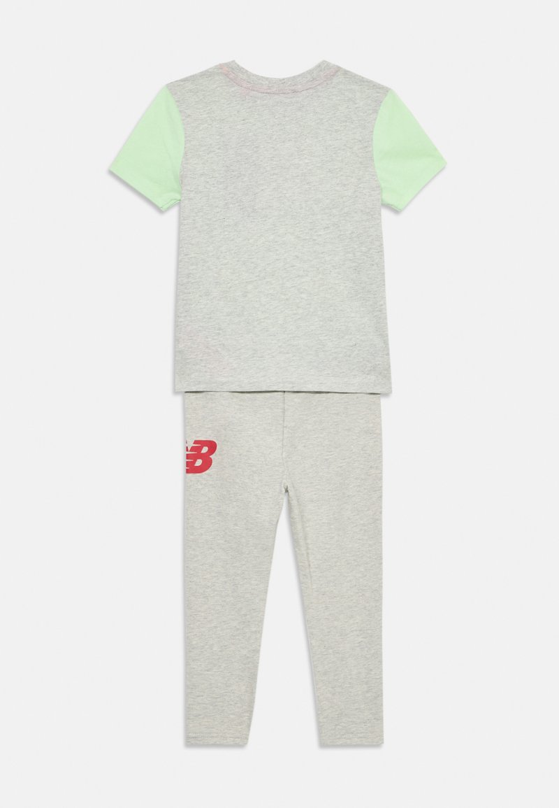 Graues Baumwoll-T-Shirt mit ätherisch grünen Ärmeln, kombiniert mit grauen Leggings, die ein rotes New Balance-Logo aufweisen. Weiche Textur, lässiges Design.