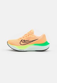 Chaussure de course Nike orange vif avec logo swoosh noir, semelle néon verte et blanche, et bande de roulement noire, présentée de profil sur fond blanc.