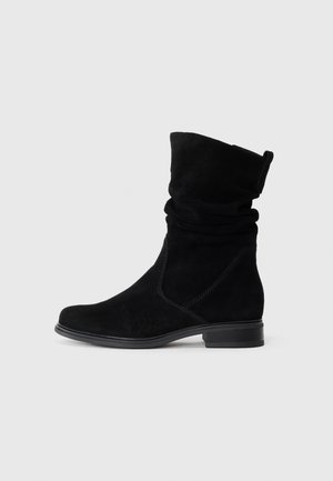 Sort mocka støvle til midt på læggen med lav stacket hæl, rund tå og sløset overdel, vist i sideprofil på en ensfarvet baggrund.