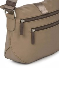 Bruine nylon crossbodytas met twee ritssluitingen, een gestructureerde band en contrasterende hardware. Afgeronde vorm en gladde afwerking.