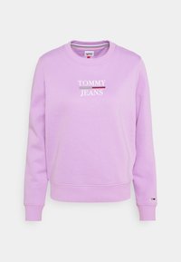 Lila sweatshirt med rund hals och ribbad mudd. Den har "TOMMY JEANS"-logotypen tryckt i vitt över bröstet.