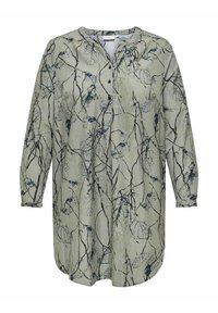 Chemise à manches longues en tissu vert clair avec un imprimé botanique en bleu foncé. Dispose d'une fermeture à boutons à l'avant et d'un ourlet arrondi.