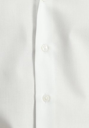 Camisa blanca de botones con tela texturizada, con dos botones visibles en el centro, mostrando un diseño limpio y clásico.