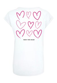 Balta trumpa rankovė t-shirt, kurios nugarinėje pusėje yra įvairių rožinių širdelių raštas, o apačioje juodai spausdinta "PASITIKĖK SAVO ŠIRDIMI".