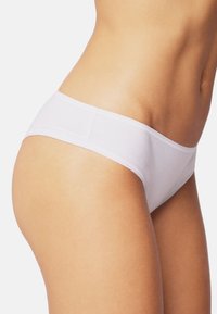 Weiße Baumwollslips mit nahtlosem Design und weichem Bund, ausgestattet mit einer glatten Textur und klassischem niedrigem Schnitt.