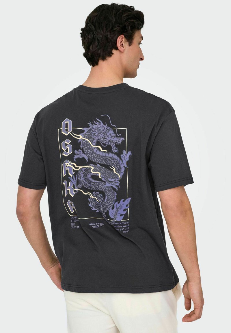 Sort bomulds t-shirt med et stort lilla dragegrafik og tekst på ryggen, med en afslappet pasform og korte ærmer.
