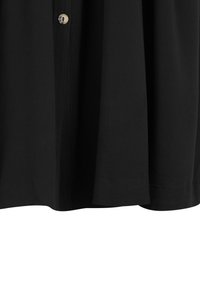 Chemise noire avec une texture lisse, dotée d'une fermeture à boutons et d'un ourlet droit. Le tissu est léger et tombe en douceur.