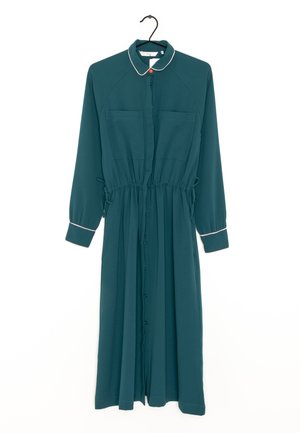 Teal long-sleeve midi dress with button front, two chest pockets, waistband ties, white trim on collar and cuffs, hanging on black hanger.