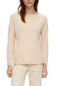 Pull en beige clair, matière tricotée douce, coupe décontractée, col rond, épaules tombantes, ourlet et poignets côtelés, détails de couture minimalistes.