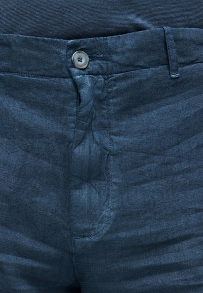 Σκούρο μπλε παντελόνι από λινό με υφή, που διαθέτει ραμμένη μπροστινή τσέπη, κλείσιμο με κουμπί και εμφανείς ραφές κατά μήκος της μέσης.