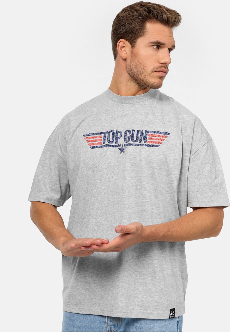 Šedé bavlněné tričko s grafikou "TOP GUN" se červenými křidélky a tmavě modrým obrysem, kulatým výstřihem a krátkými rukávy.