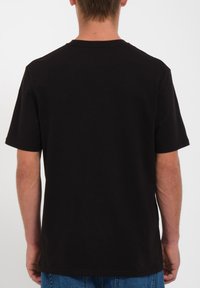Sort bomulds T-shirt med korte ærmer, rund halsudskæring og en afslappet pasform. Glat tekstur, enkel design, ingen synlige mønstre eller detaljer.