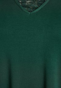 Zeleni pulover z V-izrezom iz mehke tkanine, z gladko teksturo in rahlim sijajem ter čipkasto zadrgo ob izrezu za dodaten detajl.