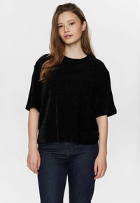 Svart, kortärmad topp i texturerad tyg med lös passform och rundad halsringning, tillsammans med mörka jeans på en enkel bakgrund.