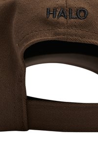 Brun stof baseballkasket med sort broderet "HALO" tekst over den justerbare stropåbning bagpå.