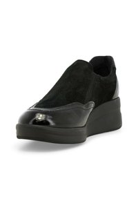 Scarpa nera slip-on con tomaia in camoscio, dettagli in vernice lucida e suola a zeppa spessa. Texture liscia con dettagli di cucitura sottili.