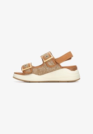 Sandalias marrones tejidas con dos correas ajustables, una plantilla acolchada y una suela de plataforma blanca. Parte superior de tela texturizada con detalles metálicos.