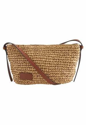 Sac bandoulière en paille tissée avec une sangle réglable en cuir marron et un patch en cuir rectangulaire à l'avant.