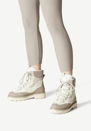 Beige en witte gewatteerde wandelschoenen met gestructureerde oppervlakken, voorzien van een met bont gevoerde kraag, dikke zool en patroon veters.
