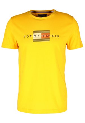 Gelbes Baumwoll-T-Shirt mit einem grafischen Design aus horizontalen Streifen und dem Text "TOMMY HILFIGER" in kontrastierenden Farben.