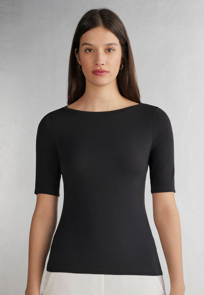 Zwart getailleerd t-shirt met korte mouwen, ronde halslijn en een gladde textuur. Eenvoudig ontwerp zonder patronen of accenten.