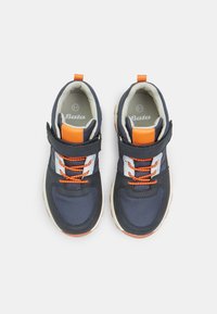 Zapatillas azul marino con acentos naranjas, material de malla, correa de velcro y cordones blancos en contraste. Suela de goma con agarre texturizado. Talla 31.