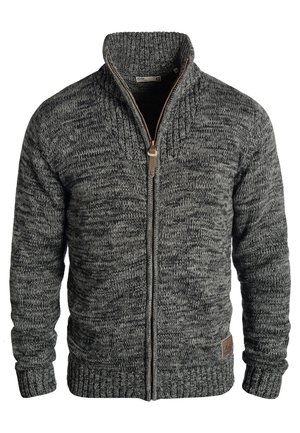 Cárdigan gris de punto con cuello alto, cierre de cremallera y puños de canalé. Presenta un patrón texturizado y un acento de logo de cuero marrón.