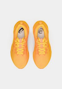 Baskets de sport jaunes avec une tige en mesh et des lacets contrastés. Elles sont dotées d'une semelle intérieure rembourrée et d'une semelle extérieure texturée pour une meilleure adhérence.