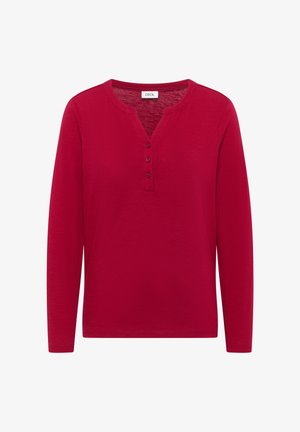 Camisa roja de manga larga hecha de tejido liviano. Presenta un escote tipo henley con tres botones y un corte relajado. Textura suave con elasticidad.