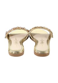 Gullige sandaler med bred rem dekorert med flerfargede edelstener; glatt såle med metallisk finish og flat såle.