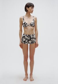 Sort-hvid mønstret bikini sæt med en bralette top med tynde stropper og en højttaljet bund, lavet af glat stof.