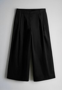 Pantaloni neri a gamba larga e corta con pieghe in vita e passanti per cintura, mostrati su uno sfondo chiaro e uniforme.