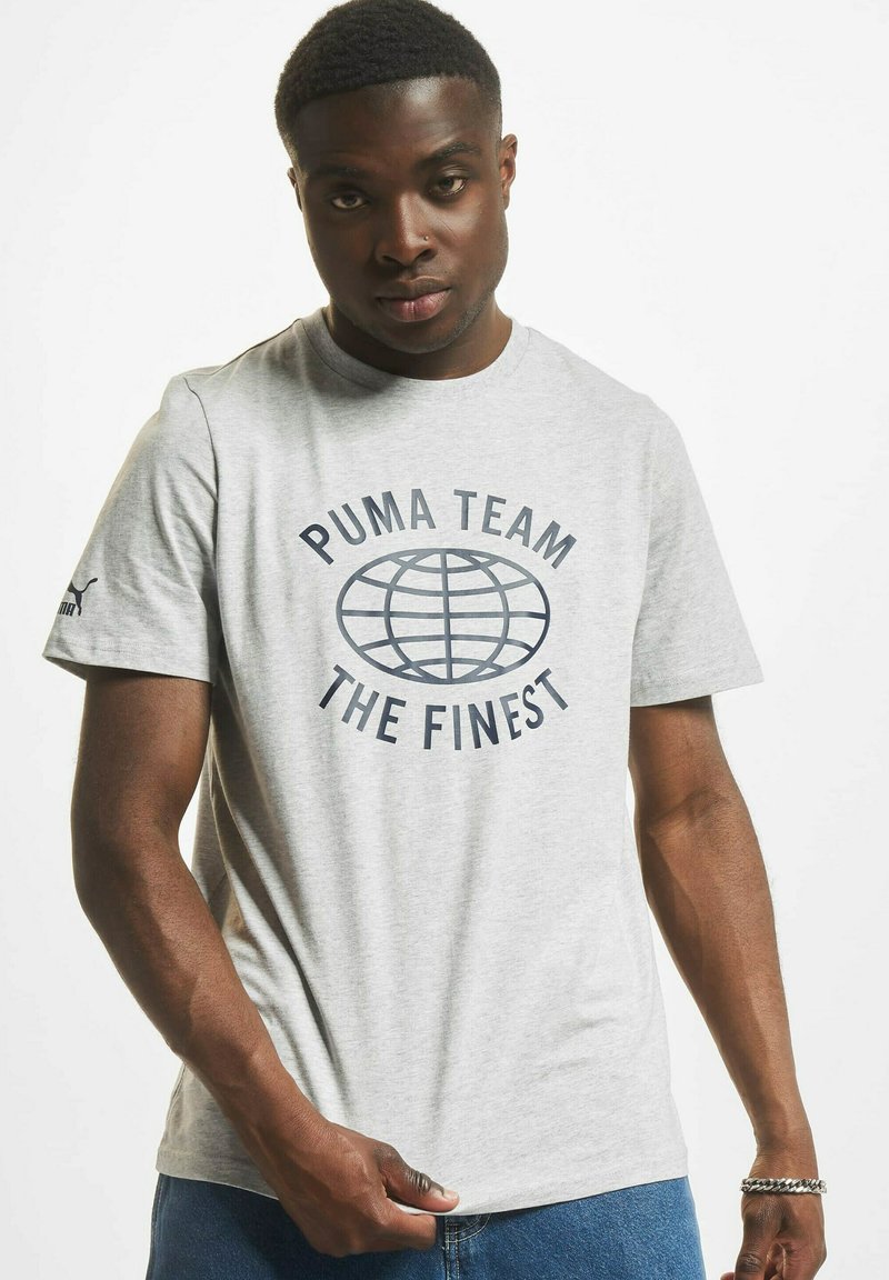 Grå bomulls t-skjorte med globe grafikk og "PUMA TEAM" samt "THE FINEST" i mørkeblå tekst. Korte ermer, rund hals-design.