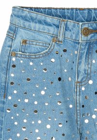 Heled sinise värviga denimilühikesed püksid, milles on ringikujulised lõiked ja metallilised aktsendid, näidates ainulaadset disaini ja eristuvat tekstuuri.