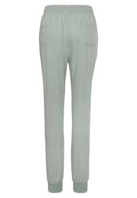 Light green jogger pants with an elastic waistband and cuffs, featuring two back pockets and a textured fabric.