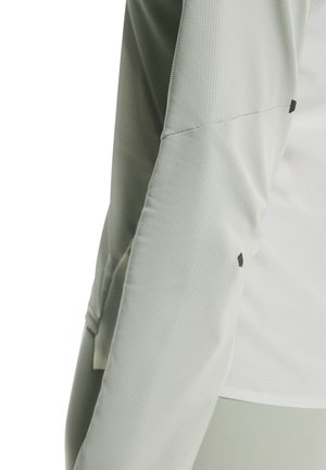 Tricou sport cu mânecă lungă, gri deschis, din material texturat, cu detalii negre pe cusătura umărului.