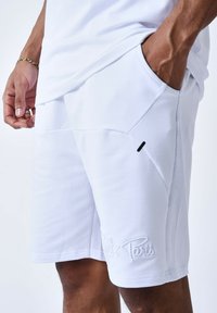Bermudas de algodón blancas con una textura suave, que presentan un diseño ajustado, bolsillos laterales y un detalle bordado de "París".