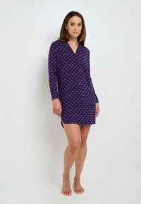 Abito viola con bottoni e maniche lunghe, caratterizzato da un motivo ripetitivo di piccole forme. Tessuto morbido con una superficie liscia.