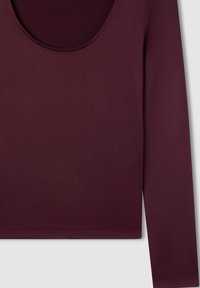 Maglietta a maniche lunghe di un profondo bordeaux, realizzata in tessuto morbido e liscio. Presenta una scollatura larga e arrotondata e bordi rifiniti.
