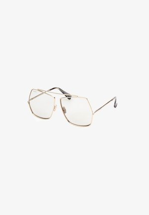 Gold metal sunglasses with a unique polygonal shape, clear lenses, and black textured temple accents. Minimalist design with refined details.