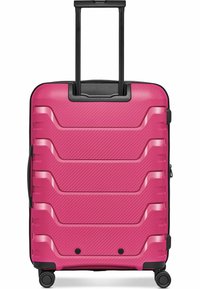 Valise rigide rose vif à quatre roues avec une poignée télescopique noire étendue, surface avant texturée avec des rainures horizontales en relief.