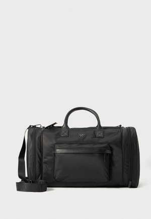 Zwarte sporttas van glad nylon met leren details, een voorvak, dubbele handvatten en een afneembare schouderband.