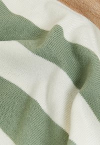 Tissu en mélange de coton avec des rayures vertes et blanches, présentant une texture douce et un léger étirement. La partie supérieure comprend un accent marron.