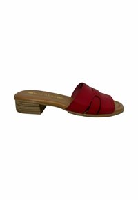 Sandal de tacón rojo con parte superior de cuero liso, que presenta correas cruzadas y un pequeño tacón cuadrado. Plantilla de color marrón claro con marca.