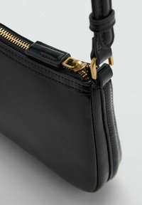 Sort læderhåndtaske med en tekstureret overflade, guld lynlås og justerbar rem. Har et slankt, minimalistisk design og kompakt form.
