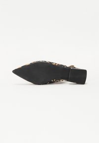 Zapato de tacón alto con estampado de leopardo y punta afilada, suela de goma negra y tacón estructurado. El material superior presenta una textura suave.