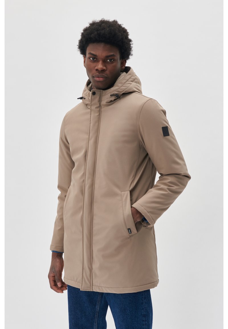 Bēgu krāsas parka jaka ar kapuci, ar rāvējslēdzēja aizdari, sānu kabatām un teksturētu apdari. Uz piedurknes ir melns logotipa uzlīme. Elastīgs materiāls.