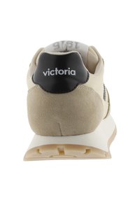 Baskets athlétiques en daim beige avec un contrefort en cuir noir. Semelle intermédiaire blanche, semelle extérieure texturée et logo "victoria" sur le talon.