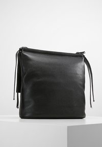 Borsa a busta in pelle nera con superficie testurizzata, forma rettangolare, chiusura con zip e dettagli con cordoncino. Design minimalista senza ulteriori motivi.